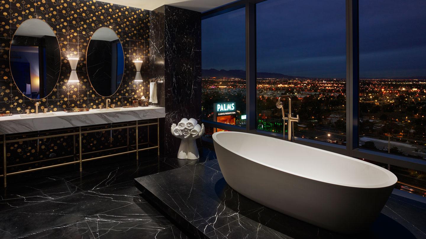 The King bedroom features pops of bronze and a black marble palette, with views of the city.