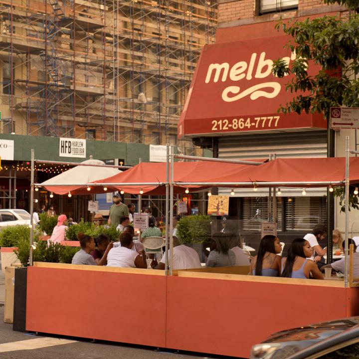 Street view of DineOut NYC outdoor dining booths outside of Melba's restaurant in Harlem