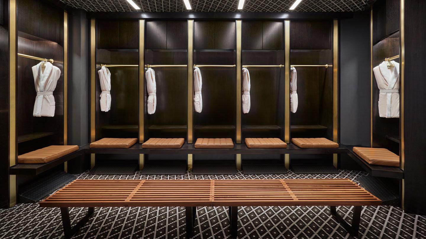 A locker room doubles as a guest bathroom, with graphic mosaic penny tiles.