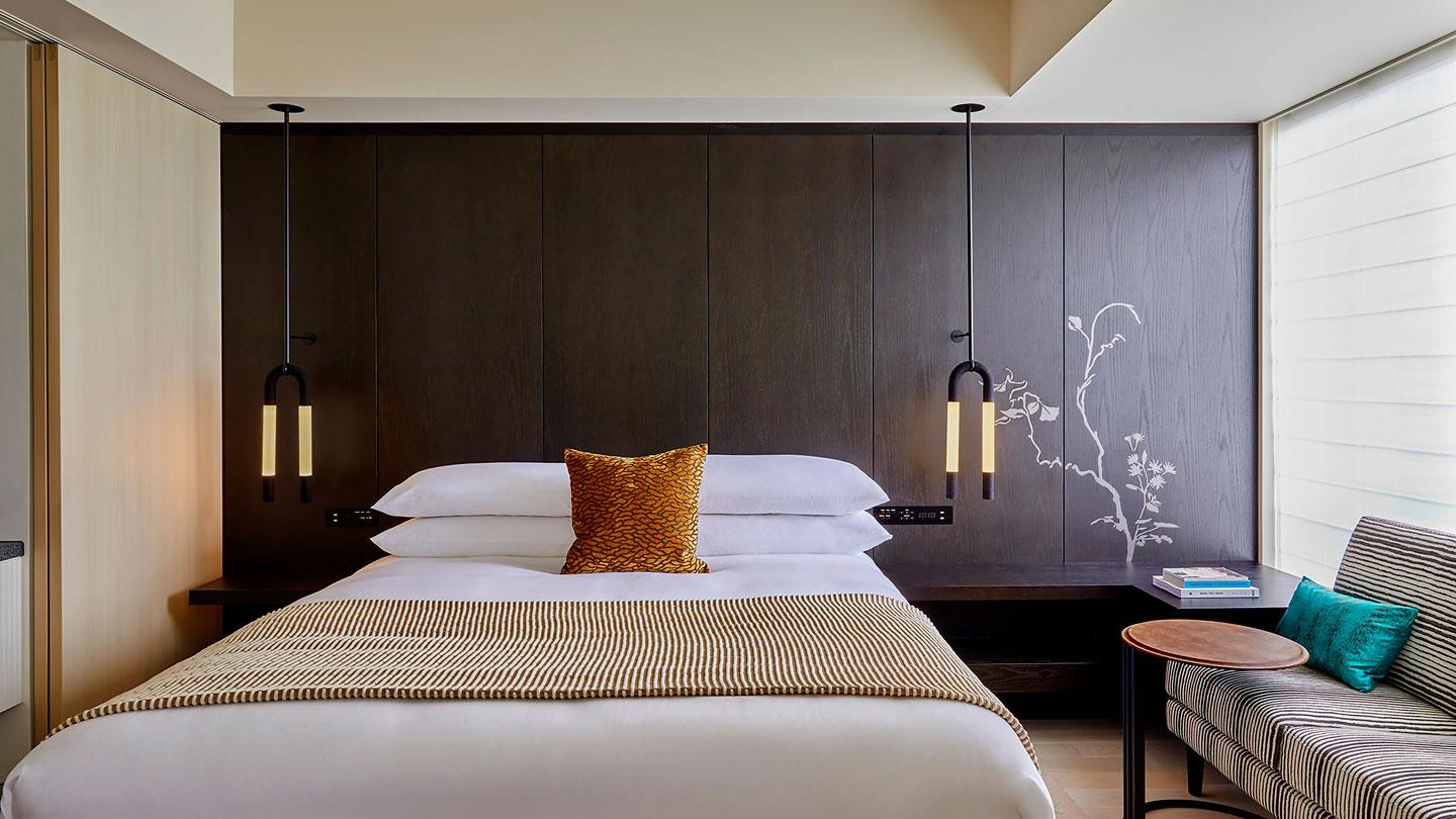 View of bed inside guestroom at Kimpton Hotel Tokyo designed by Rockwell Group