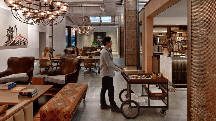 man pushing bar cart in neuehouse, nyc architect